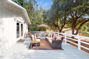 un porche con 2 sofás y una sombrilla en Uhre Family Retreat, en Oakhurst
