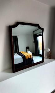 a mirror on a shelf with a bed in a room at Apartamento La Tablada in Villa General Belgrano