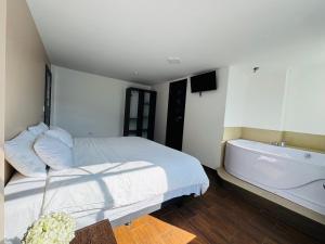 a bedroom with a bed and a bath tub at Luxury Penthouse with Jacuzzy 6 bedroom in Baños