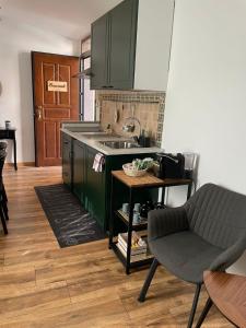 a kitchen with green cabinets and a sink and a chair at Il Giardino di Ambra Casa Vacanze indipendente in Viterbo +12 photos