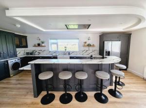 a kitchen with a large island with four stools at The Discovery Lodge in Ballykelly