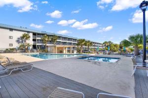 una piscina con sedie e un resort di Savannah Beach & Racquet Club 303B a Tybee Island