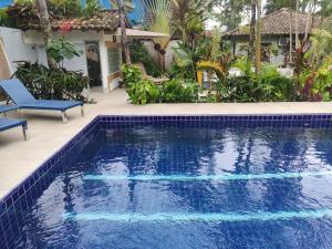 a swimming pool in front of a house at Eliconial Paraty Pousada in Paraty