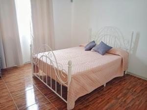 a white bed with blue pillows in a bedroom at Villa Bella is 5 mins from the beach with amazing garden overlooking the pool in Trou dʼ Eau Douce +32 photos