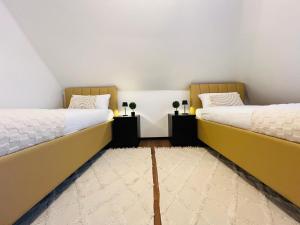 two beds in a room with white walls at Charmante Wohnung nahe Stadtzentrum in Bielefeld
