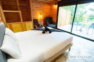 Ένα ή περισσότερα κρεβάτια σε δωμάτιο στο BNB TOULOUSE - Le Chalet des coteaux - Cadre magnifique - WiFi - Parking
