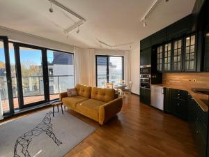 a living room with a couch and a kitchen at Happy Moments - widokowy apartament in Jelenia Góra
