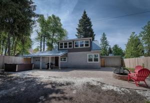 una casa con una silla roja y una valla en Park Street Cottage by Casago McCall - Donerightmanagement, en McCall