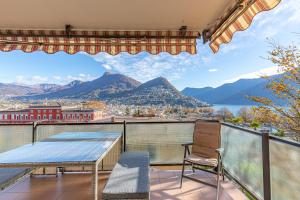 balcone con tavolo, sedie e montagne di Imperial of Lugano 4 with a lake view behind the station and 10 min from the lake a Lugano