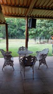a table and chairs under a pavilion with a tv at Chacara recanto mineiro in Jarinu +2 photos