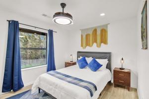 a bedroom with a bed with blue curtains and a window at Yosemite Forest Villa in Oakhurst
