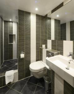 a bathroom with a toilet and a sink and a shower at New Linden Hotel in London