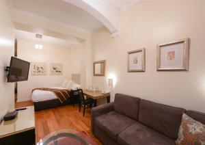 a living room with a couch and a bed at New Linden Hotel in London