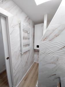 a room with white marble walls and a white closet at Les Coquelicots - Parking privé, Terrasse, Clim, Netflix, Au Calme in Hem-Lenglet +25 photos
