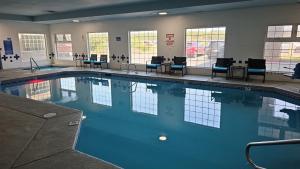 a large swimming pool with chairs and tables in a building at Lighthouse Suites Inn in Ocean Shores