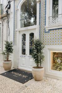 a store door with two potted trees in front of it at M'AR De AR Auria in Lisbon