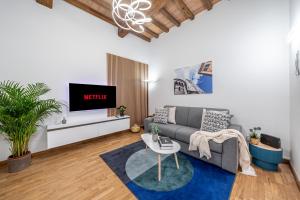Martin's Home - Large Design Apartment, Fast Wi-Fi, Free Parking, AC in Modena Historic Center في مودينا: غرفة معيشة بها أريكة وجهاز تلفزيون