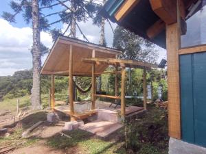 a house with a gazebo in the yard at Na'raucária in Cambará