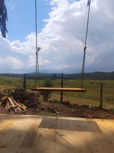 a wooden bench sitting on top of a field at Na'raucária in Cambará