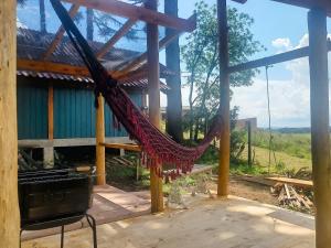 a hammock in front of a house with a view at Na'raucária in Cambará