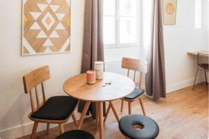 a dining room with a table and four chairs at Bancel- Jean Macé in Lyon +3 photos
