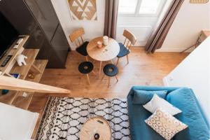 a living room with a blue couch and a table at Bancel- Jean Macé in Lyon