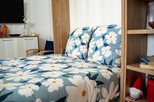 een bed met een blauw-wit dekbed met witte bloemen bij Wonderful Apartment in Ferragudo 2Double Beds near Beaches and Golf in Ferragudo