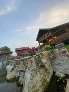 a house on the water with flowers on a stone wall at Vikendica Ana in Šipovo +28 photos
