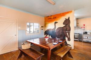 a dining room with a table and a painting on the wall at Mungo Shearers' Quarters in Mungo
