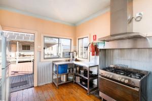 a large kitchen with a stove and a balcony at Mungo Shearers' Quarters in Mungo