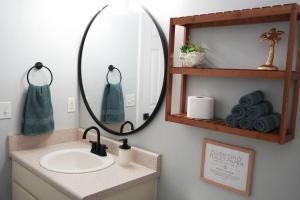 a bathroom with a sink and a mirror and towels at 5 Min To Navarre Beach Patio Cute Design Kitchen in Navarre +10 photos