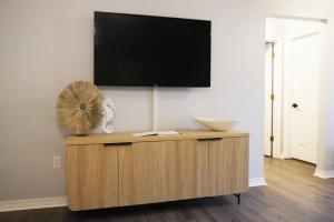 a flat screen tv on top of a cabinet with a fan at 5 Min To Navarre Beach Patio Cute Design Kitchen in Navarre