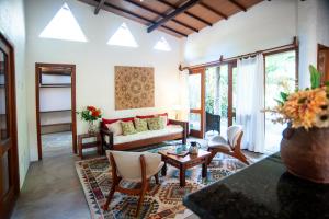 a living room with a couch and a table and chairs at Casas Natureza Brasil in Arraial d'Ajuda