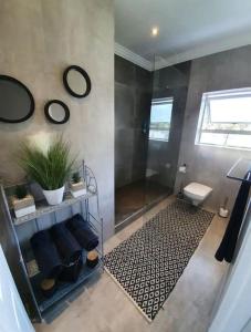 a bathroom with a shower and a bench and mirror at A Stone's Throw in Gqeberha +24 photos