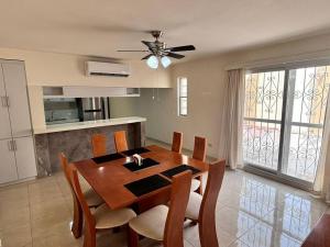 a dining room table with chairs and a ceiling fan at Amplia casa cerca malecón in La Paz