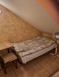 a small bedroom with a bed and a chair at Pokoje Gościnne Gracja in Kupiski Stare