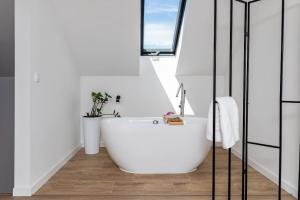a bathroom with a white tub and a window at TOP house with private HOT TUB-near sea, lakes and forest in Kołczewo +12 photos