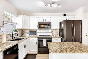 a kitchen with white cabinets and a stainless steel refrigerator at Cute Design BBQ Pets Full Kitchen Fire Pit Park in Gilbert