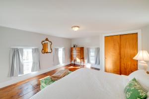 a bedroom with a white bed and a wooden floor at Less Than 4 Mi to Cooperstown Charming Historic Home! in Fly Creek
