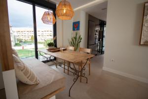 een eetkamer met een tafel en een bank bij Luxury penthouse with private pool in El Campello
