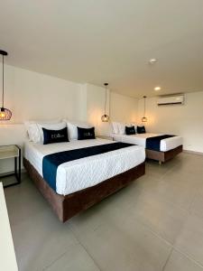 two beds in a hotel room with two lamps at Hotel ECO 44 in Medellín +22 photos