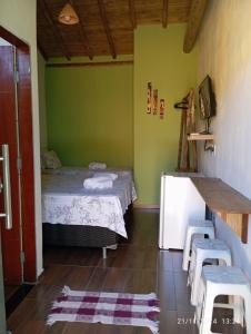 a room with a bed and a table and chairs at Suíte Trancoso in Trancoso