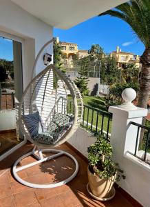 ein Schaukelstuhl auf einem Balkon mit einer Palme in der Unterkunft La muńeca in Mijas + 29 Fotos