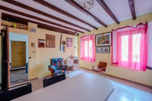 a room with pink curtains and a table and chairs at Casa Daniele in Savigno +9 photos