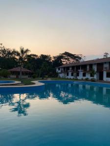 Tantiri River Resort في بويرتو مالدونادو: حمام سباحة أزرق كبير أمام مبنى