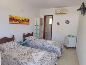 a room with two beds and a mirror at Morada das Palmeiras in Barra Grande