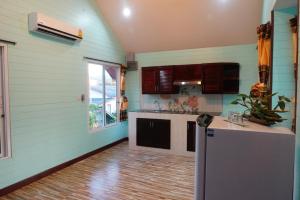 a kitchen with blue walls and a counter and a window at Ruen Tai Boutique in Nai Yang Beach