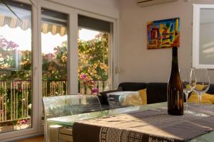a glass table with a bottle of wine on it at Apartments Milica in Krilo