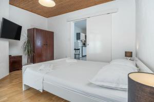 a white bedroom with a large bed and a mirror at Apartments Milica in Krilo +12 photos