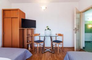 Pokój ze stołem z 2 krzesłami i telewizorem w obiekcie Apartments Brane w mieście Zadar